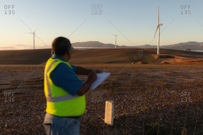 Engineer taking notes on a writing pad at a wind farm