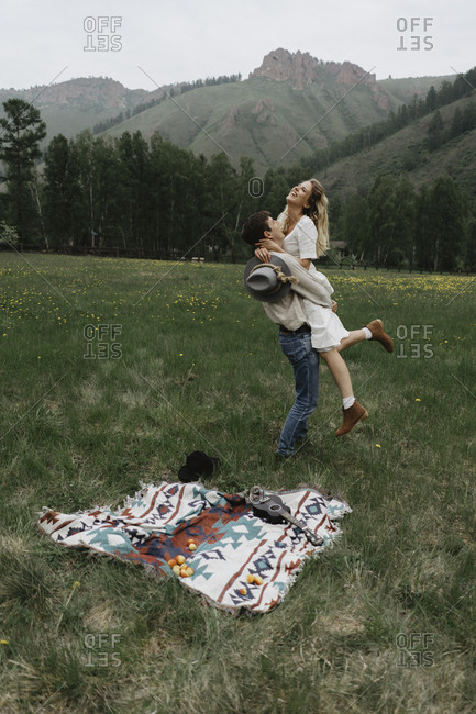 Man lifting woman in the air in a field