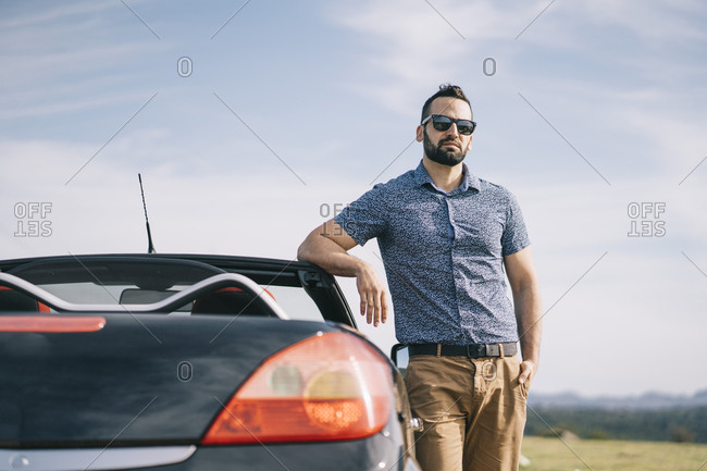 Young man poses with his car in his navy blue business suit Stock Photo |  Adobe Stock