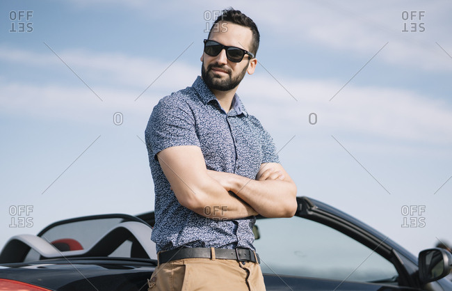 Fashionable man posing on a luxury car on Craiyon