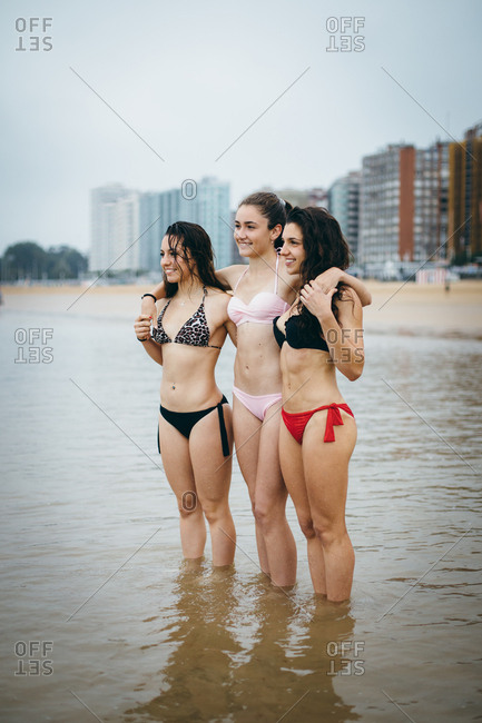 Three fit girls enjoying summer vacation together at the beach. Gijon, Asturias, Spain.