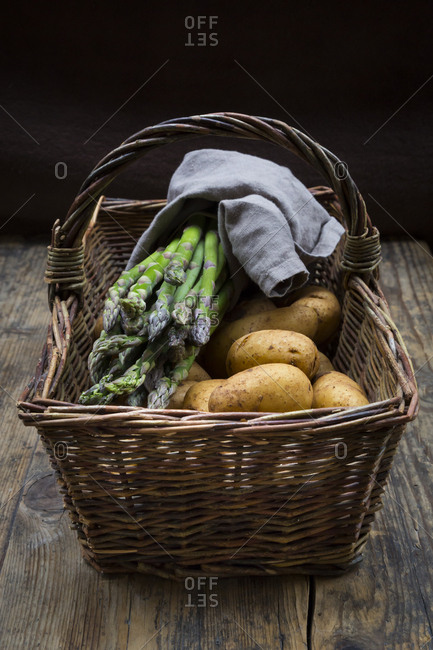 Organic green asparagus and organic potatoes in wickerbasket