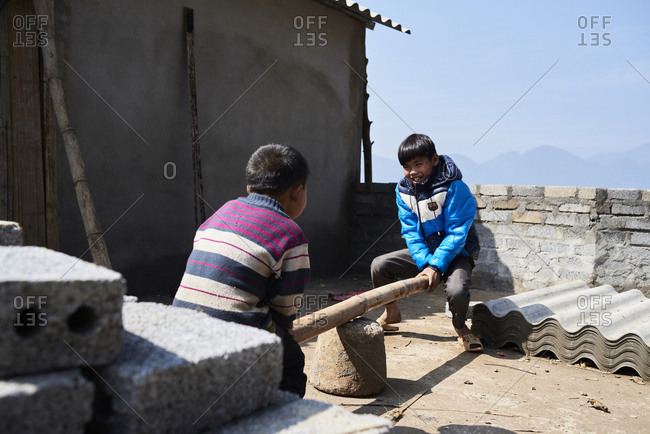 Ha Giang, Vietnam - February 15, 2018: Best friends swinging with handmade swing in abandoned building.