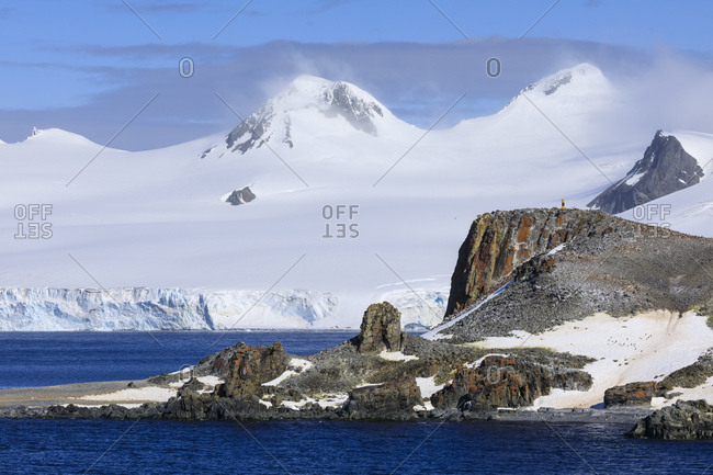 Distant penguins on Half Moon Island, Livingston Island in mist, evening sun, South Shetland Islands, Antarctica, Polar Regions