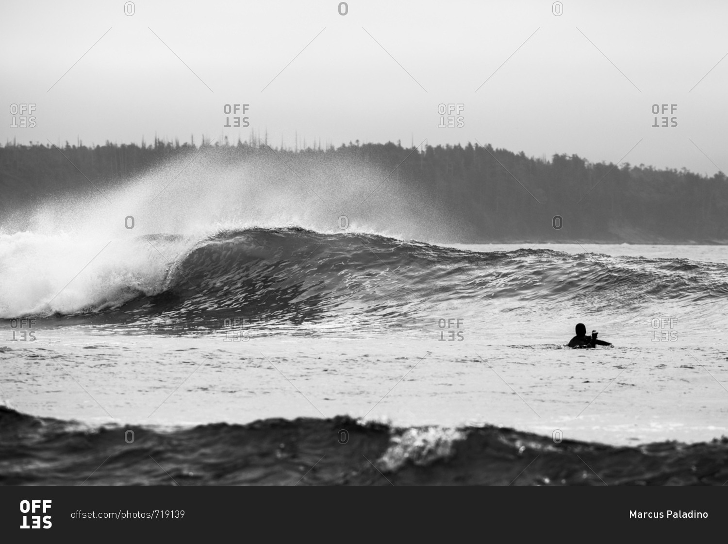 Surfer in water waiting for approaching large wave