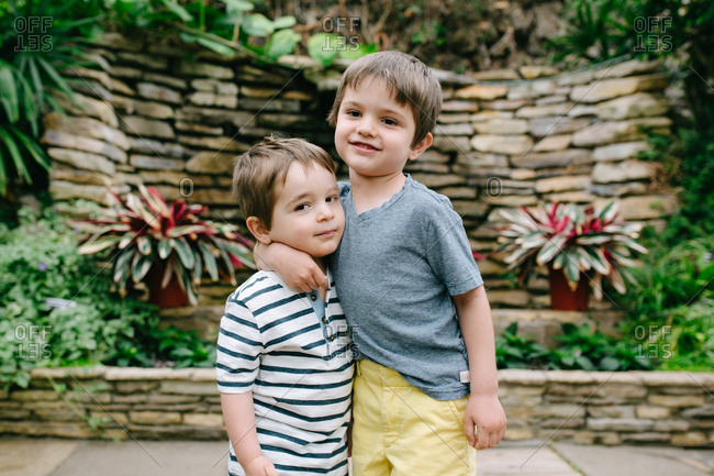 Two boys hugging at a botanical garden