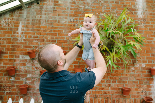 Father holding baby girl in the air