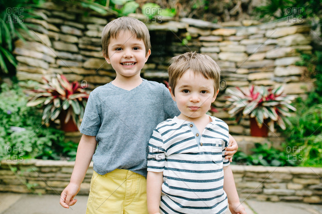 Two brothers hugging at a botanical garden