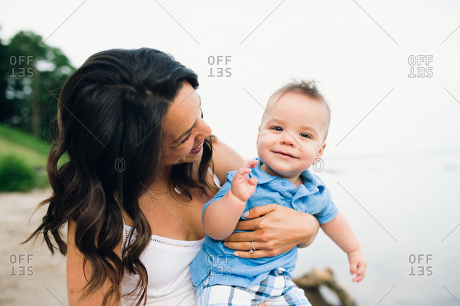 Happy mother holding baby boy outdoors