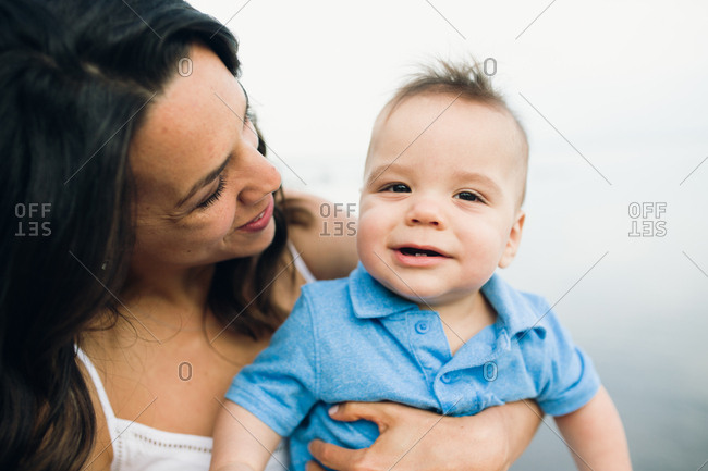 Close up of happy mother holding baby boy outdoors