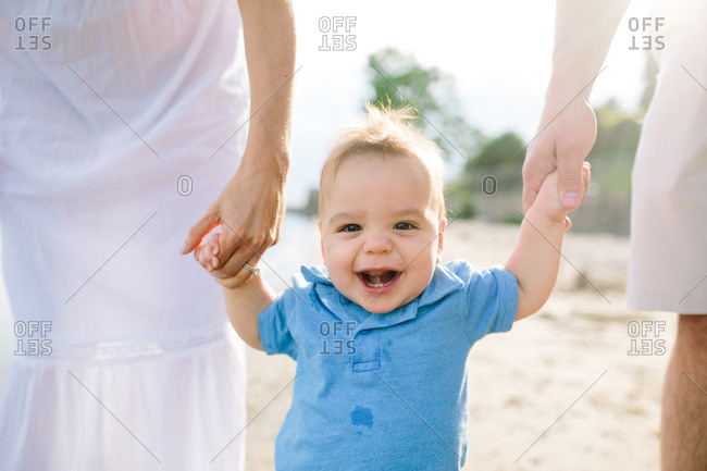 Happy family holding baby on a beach