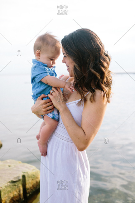Happy mother kissing baby boy on a beach