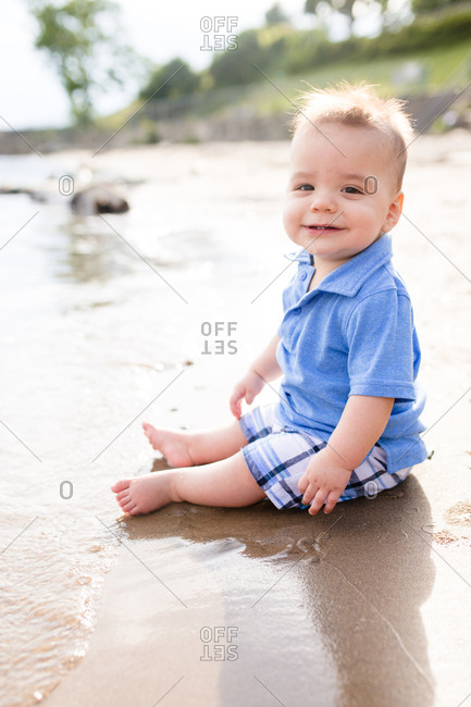 Baby sitting on wet sand on a beach