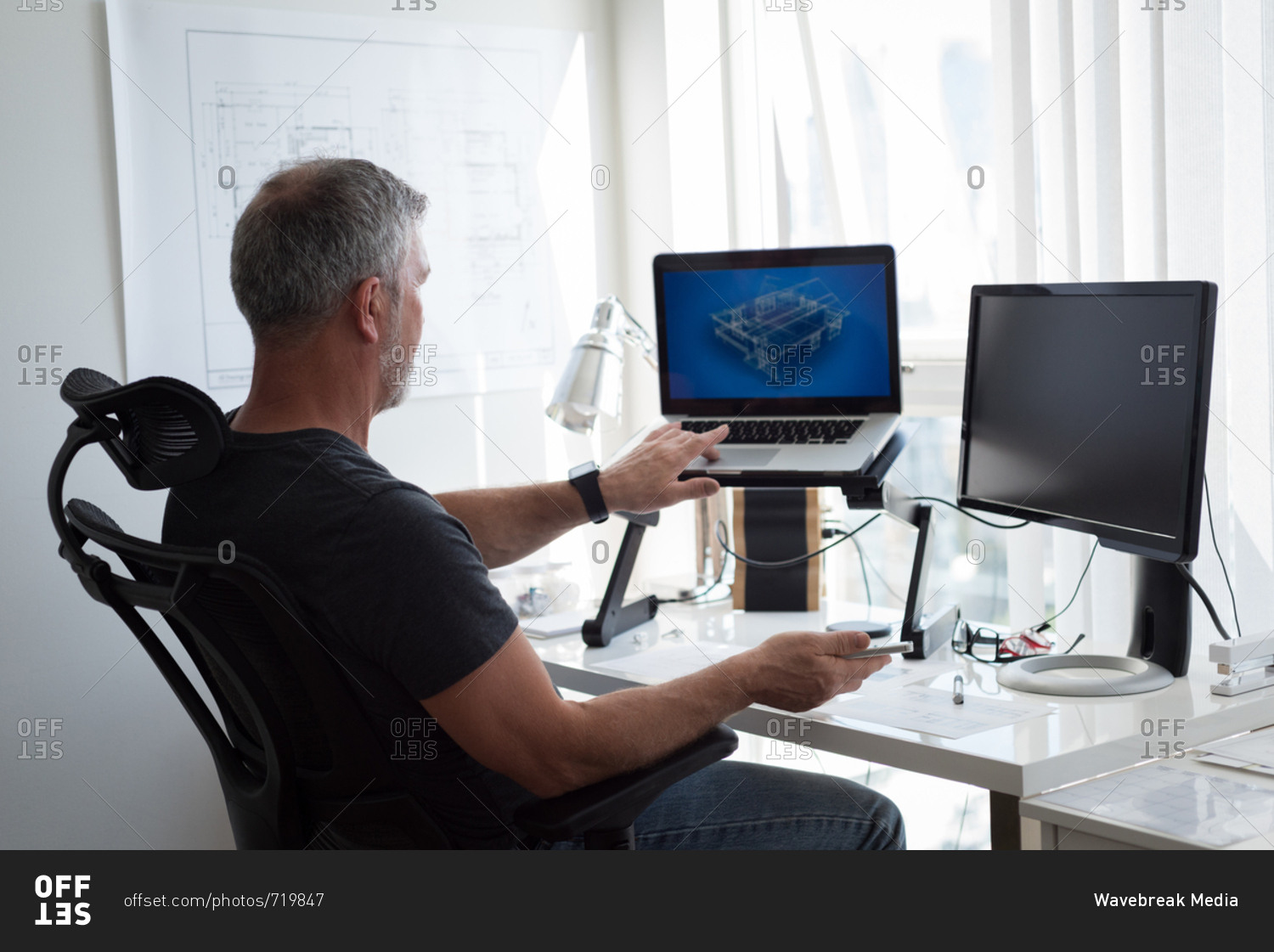 Man preparing architectural design on laptop and computer at home stock ...