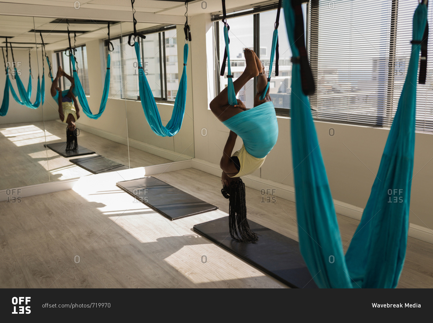 Woman exercising on swing sling hammock at fitness studio