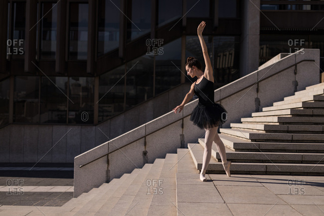 Woman performing ballet on the steps in the city