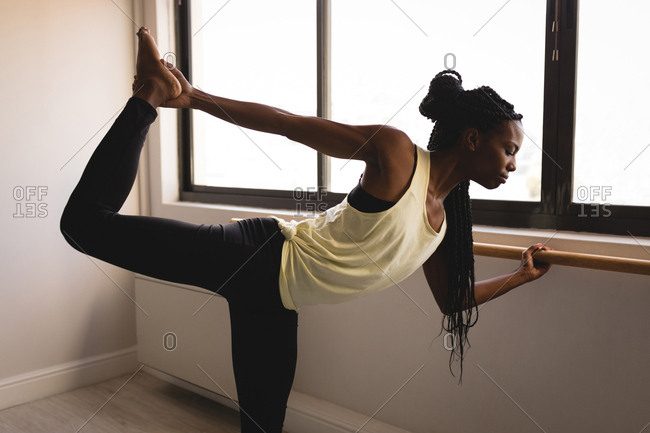 Woman performing barre exercise in Woman performing barre exercise in fitness studio