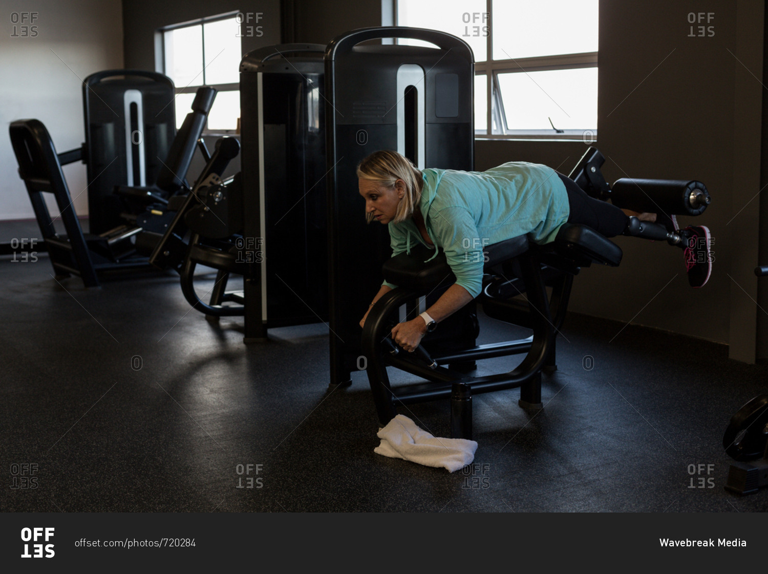 Disabled woman exercising on machine in the gym