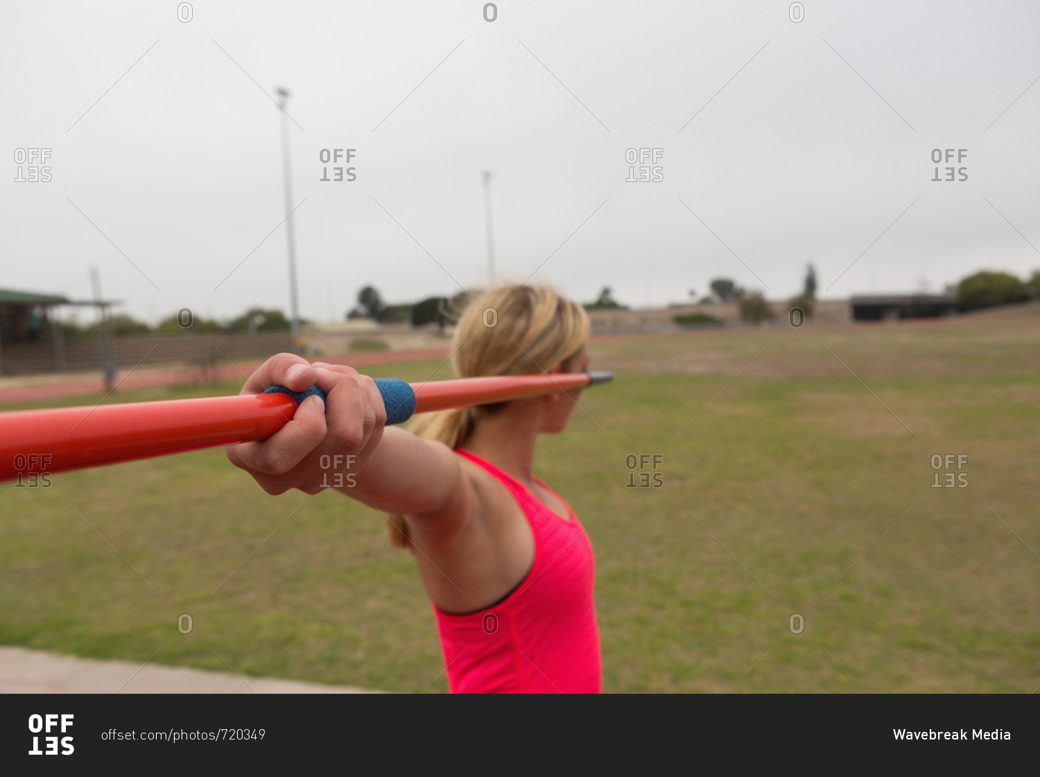 Female athlete practicing javelin throw at sports venue