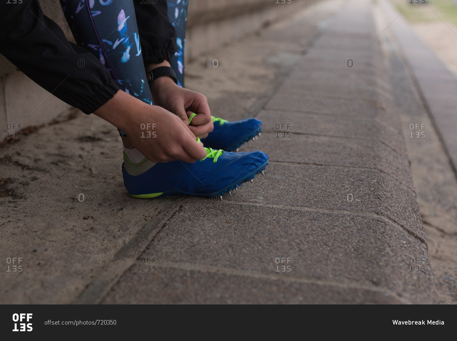 Female athlete tying shoelaces at sports venue