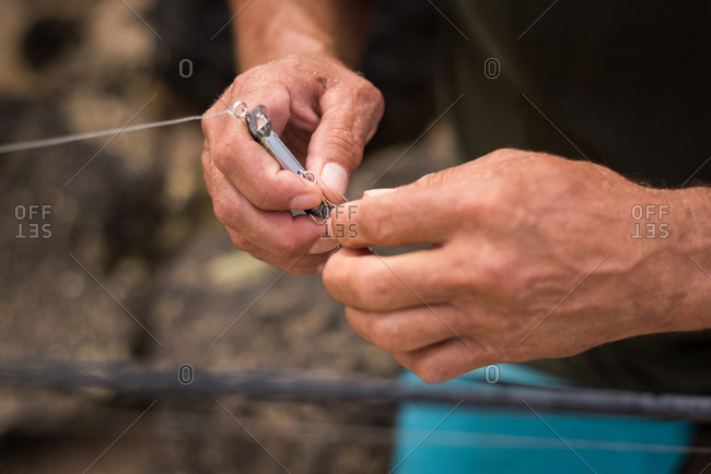 Mid section of fisherman holding fishing tackle