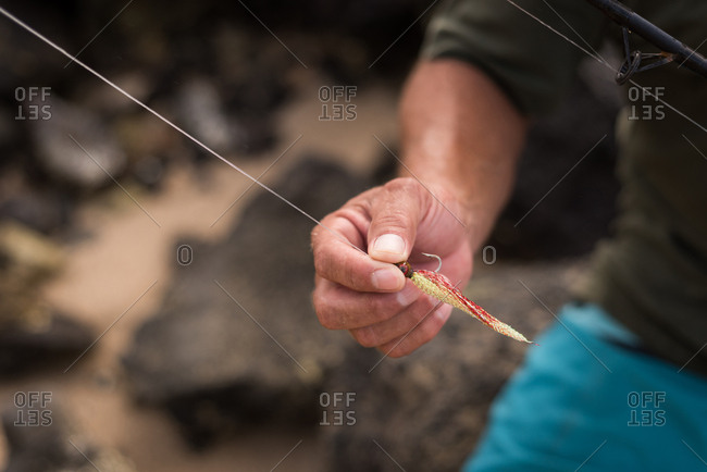 Mid section of fisherman holding fishing tackle