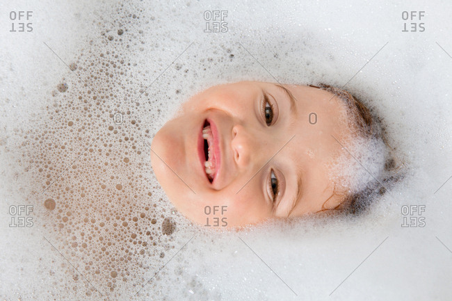 Overhead view of little girl in a soapy bubble bath
