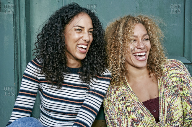 Portrait Of Two Young Smiling Women With Long Curly Black And