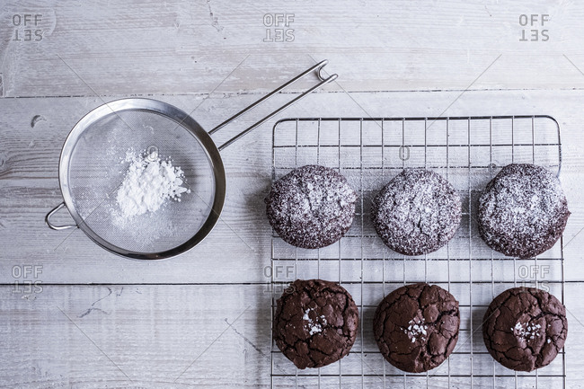 A Tray Of Cooling Chocolate Brownies And A Sieve With Icing Sugar