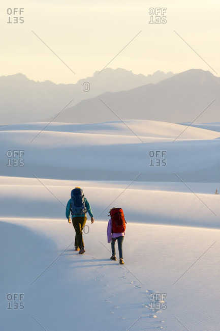 Rear view of woman and girl hiking in White Sands National Monument, Alamogordo, New Mexico, USA