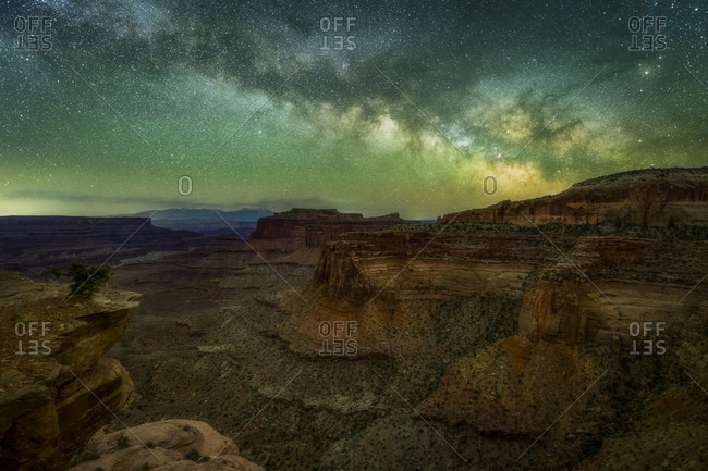 Majestic view of canyon under stars and Milky Way galaxy in sky at night, Canyonlands National Park, Utah, USA