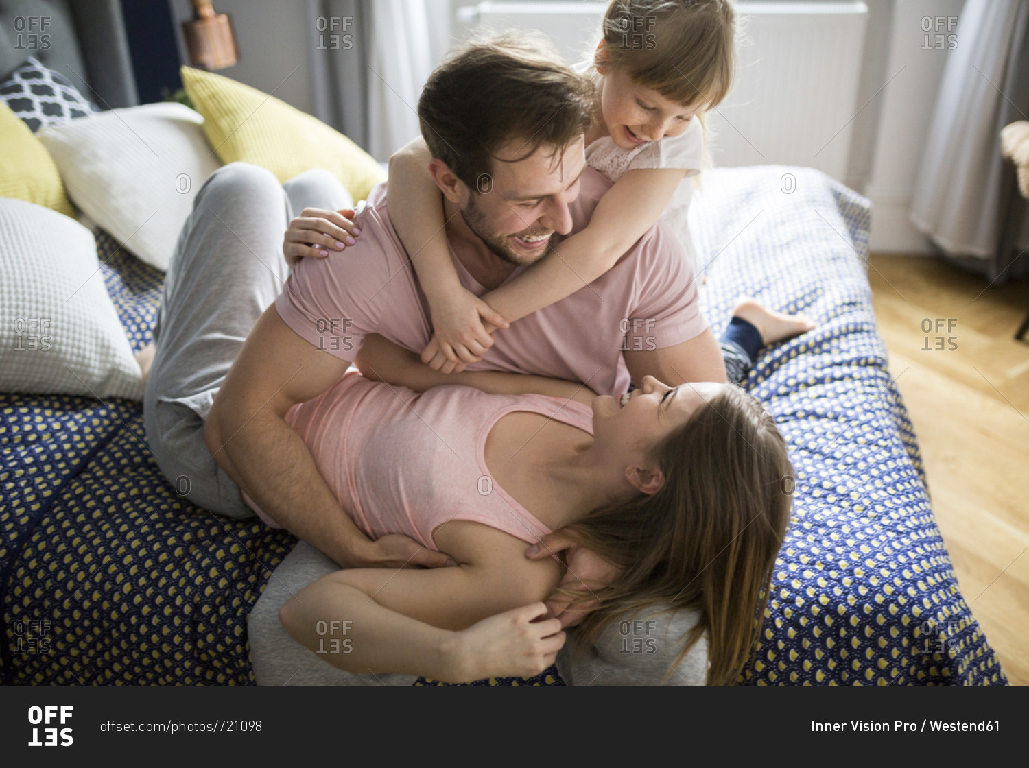 Happy family lying in bed- cuddling