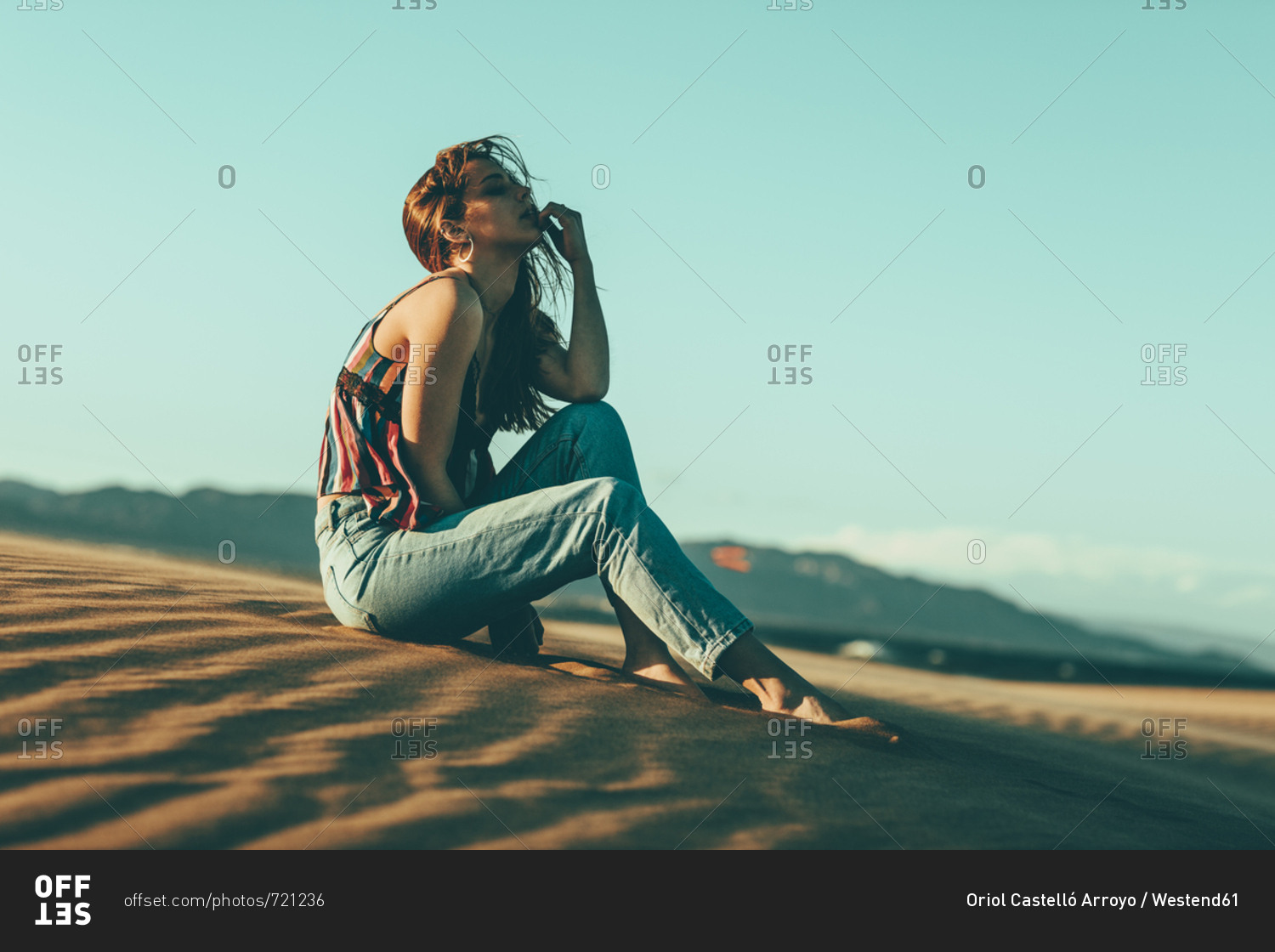 Young woman sitting in desert landscape
