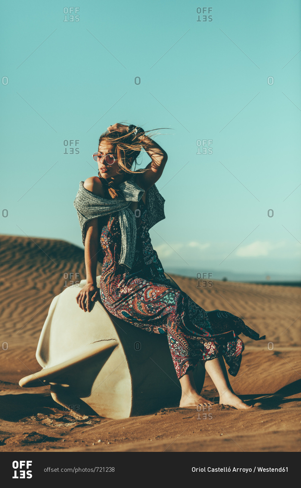 Young woman sitting in desert landscape