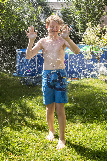 Boy in the garden splashed with water