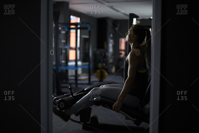 Full length shot of woman exercising in gym with exercise machine
