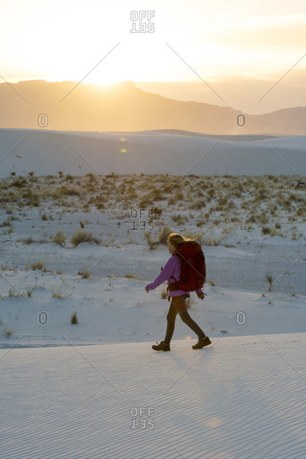 Side view of girl hiking at sunset in White Sands National Monument, Alamogordo, New Mexico, USA