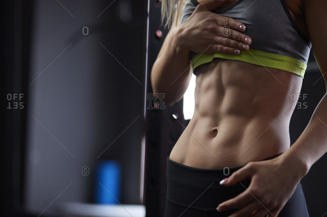 Mid section shot of woman with muscular abdomen in gym