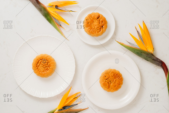 Vietnamese Mid-Autumn Festival moon cakes with tropical bird of paradise flowers