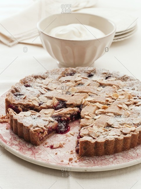 Linzer torte (nut and jam layer cake) with sliced almonds, partly sliced