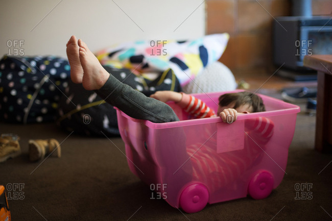 Boy playing in big plastic tub after tipping out his toys