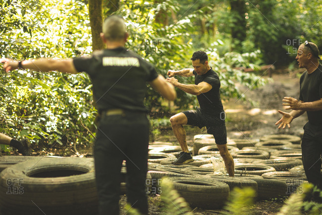 Fit men training over tires obstacle course at boot camp
