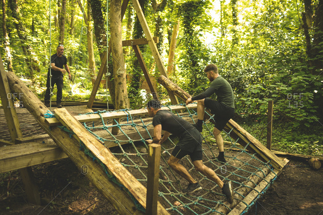 Fit men training over obstacle course at boot camp