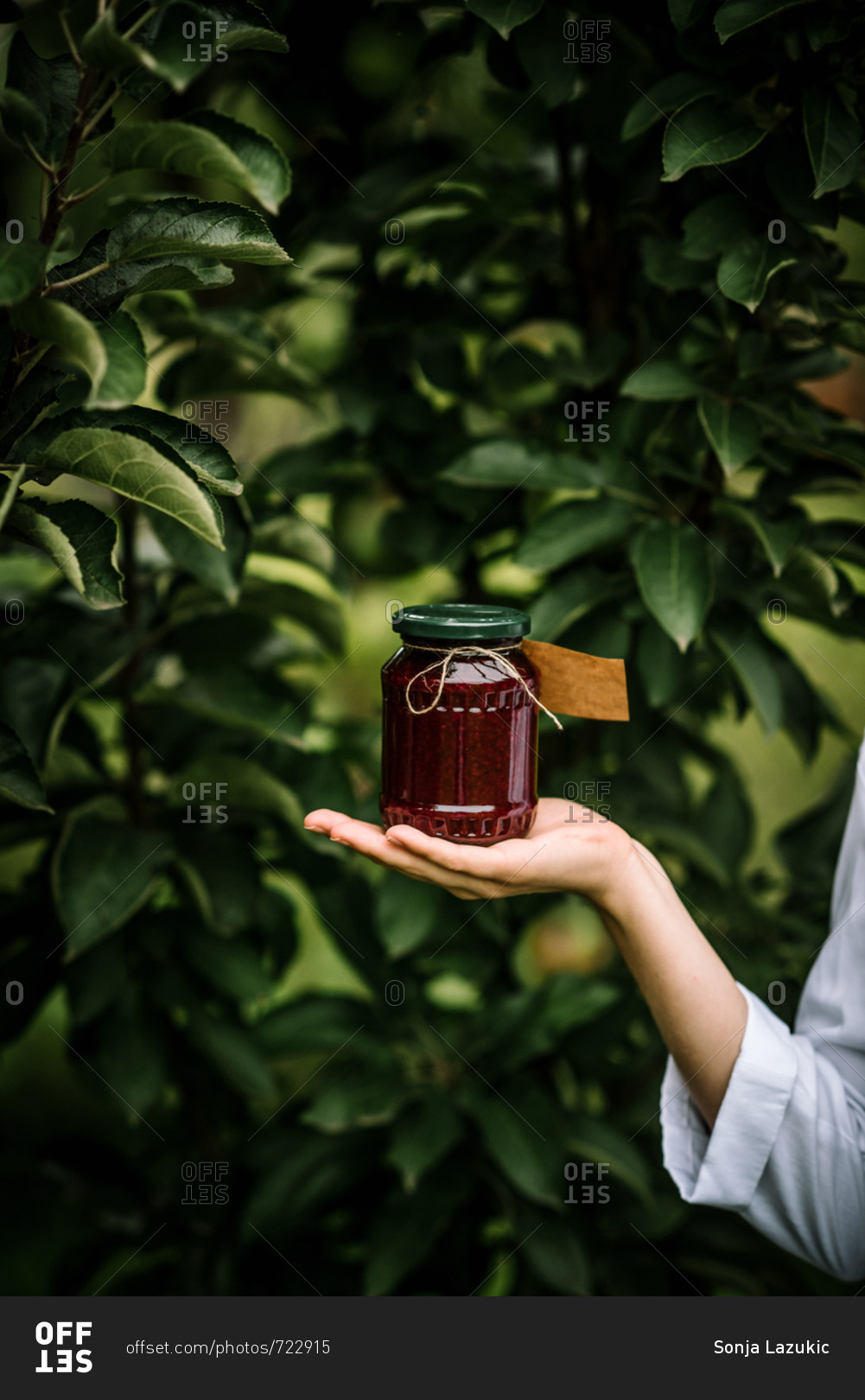 Woman holding jar of jelly with blank label