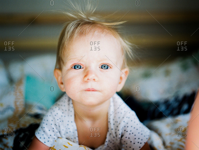 Blonde baby with blue eyes and messy hair
