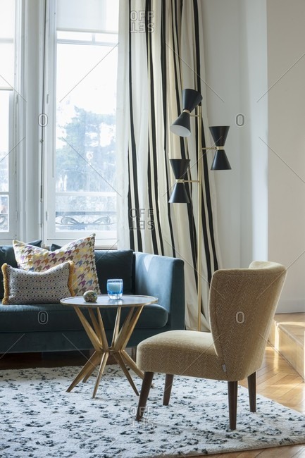 Retro Armchair And Side Table In Front Of Couch Below Window Next