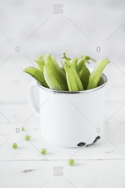 Pea pods in an enamel mug
