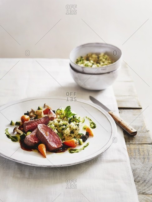 Poached saddle of lamb with mint couscous and spring vegetables