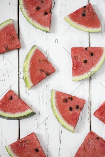 Watermelon slices on a white wooden surface (seen from above)