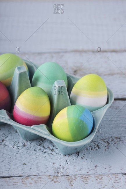 Brightly striped Easter eggs in china egg box